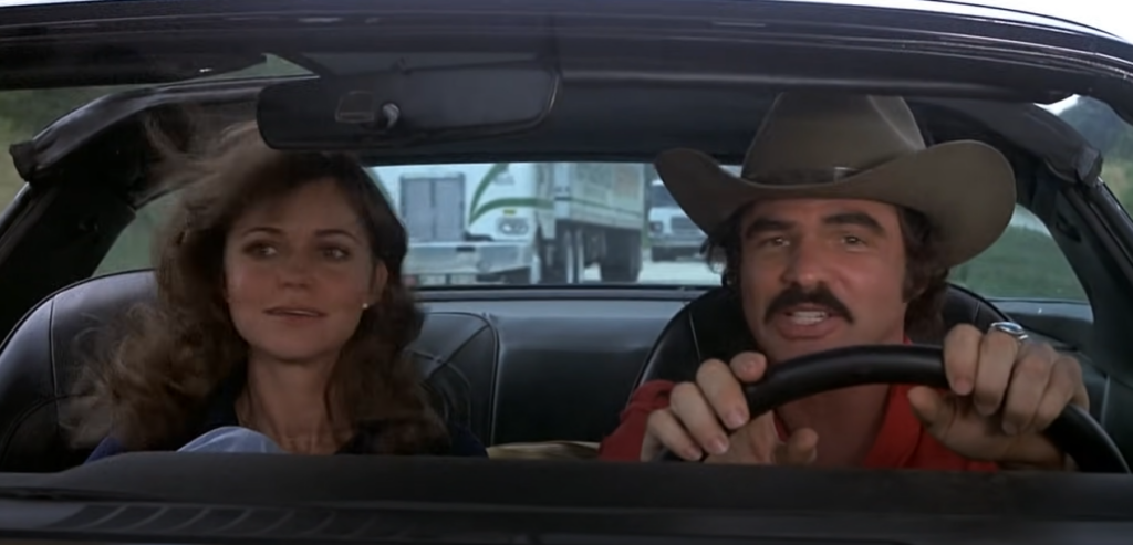 Screenshot from movie 'Smokey and the Bandit' showing 2 people inside a moving car