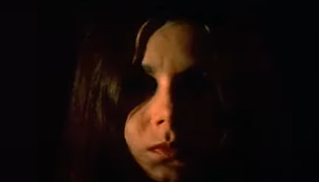 Close-up of a girl's face in the dark with darkened eyes
