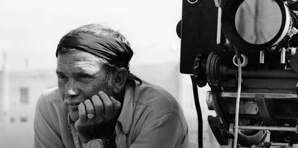 Black and white picture of Sam Peckinpah with a camera