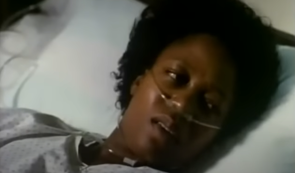 Curly-haired woman resting on a hospital bed