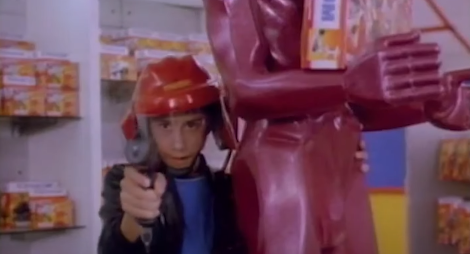 A kid wearing a helmet and holding a toy gun