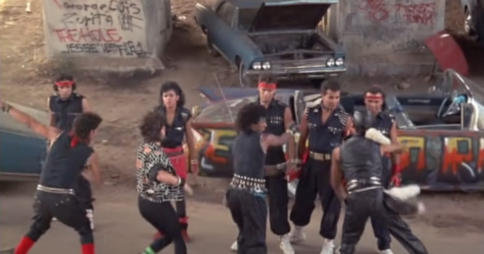 A group of people wearing nearly identical clothes dancing together in one area