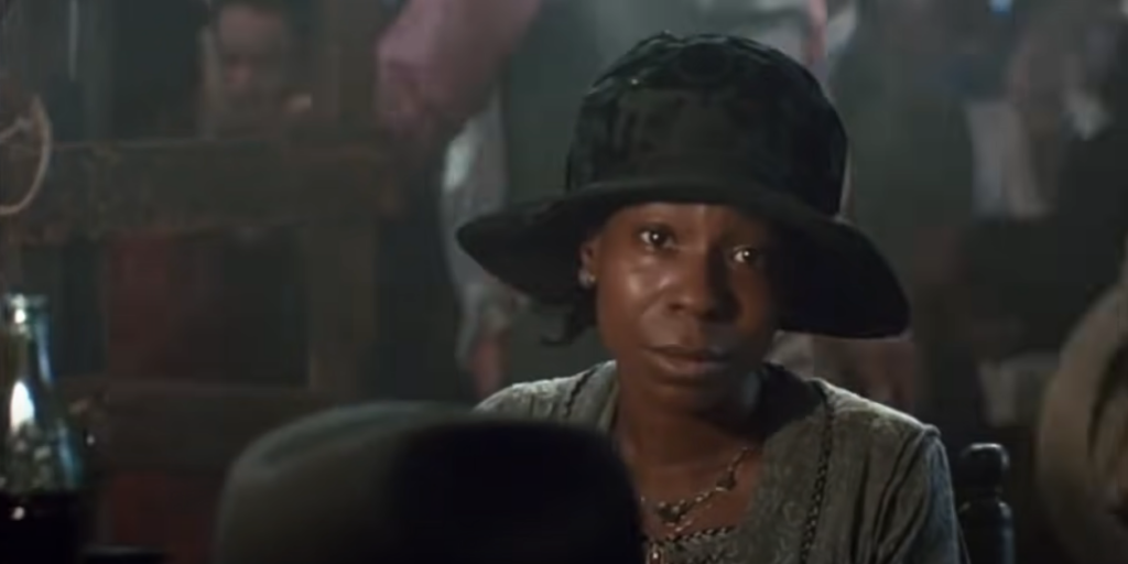 African American woman wearing a bucket hat, looking focused at the camera