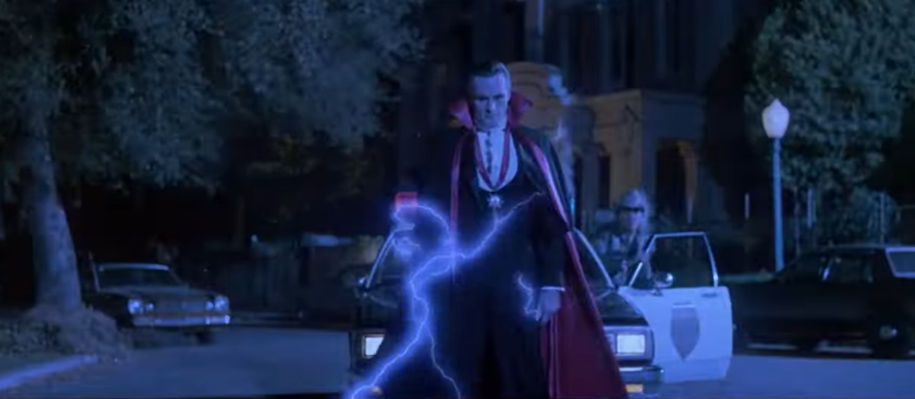 man in black and red coat surrounded by lightning standing on the street at night