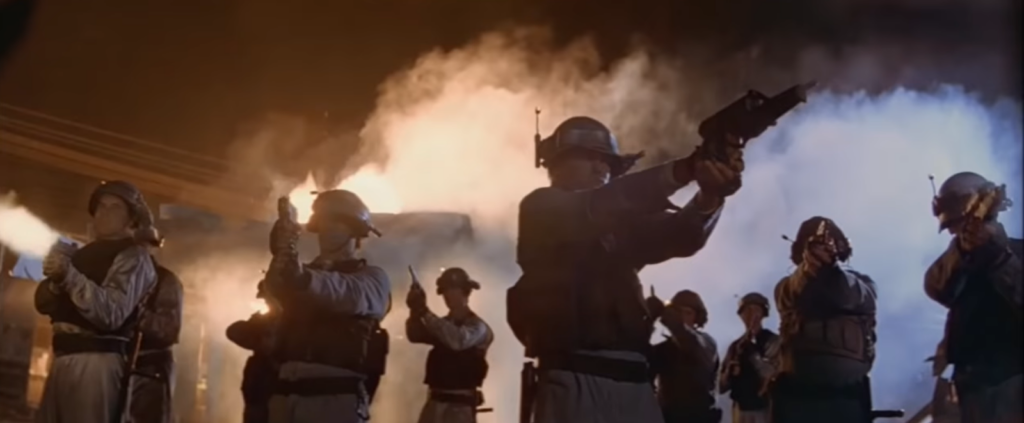 group of men in helmets holding guns and smoke behind them