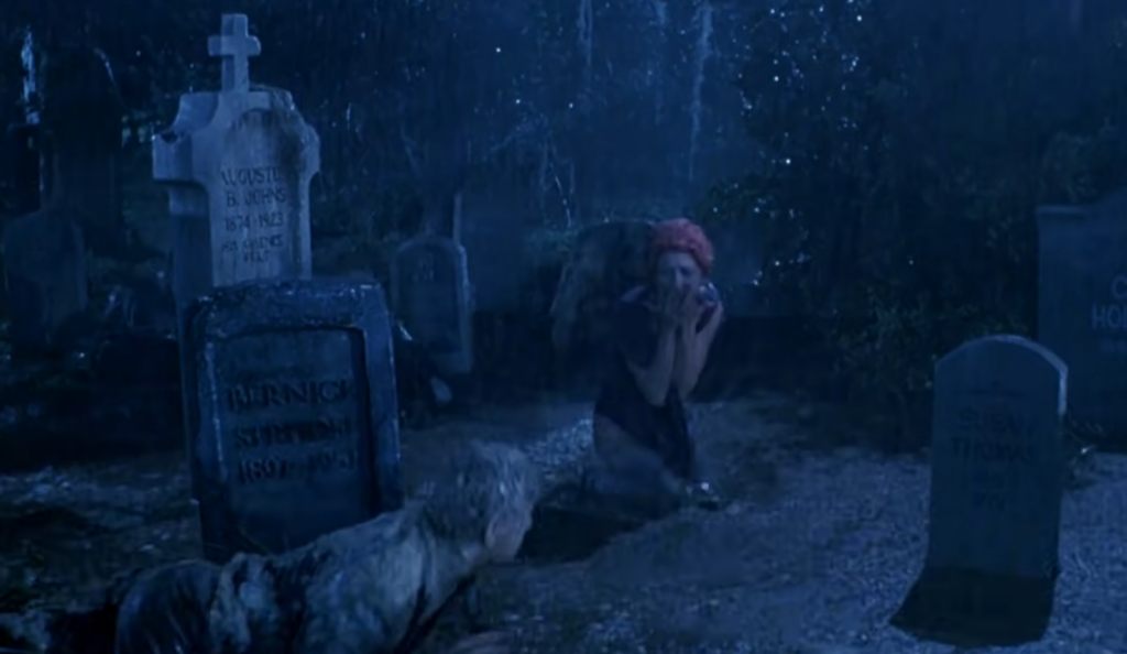 screaming woman in the cemetery and a zombie that climbs out of the grave